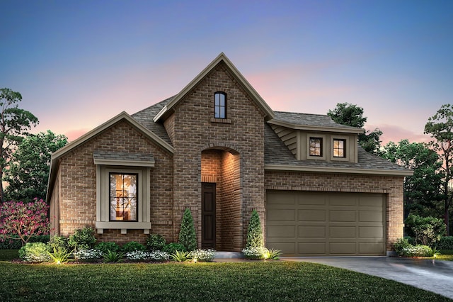 view of front of house featuring a garage and a lawn