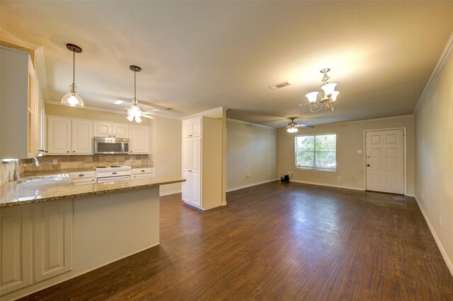 kitchen with kitchen peninsula, sink, ceiling fan with notable chandelier, and white cabinets