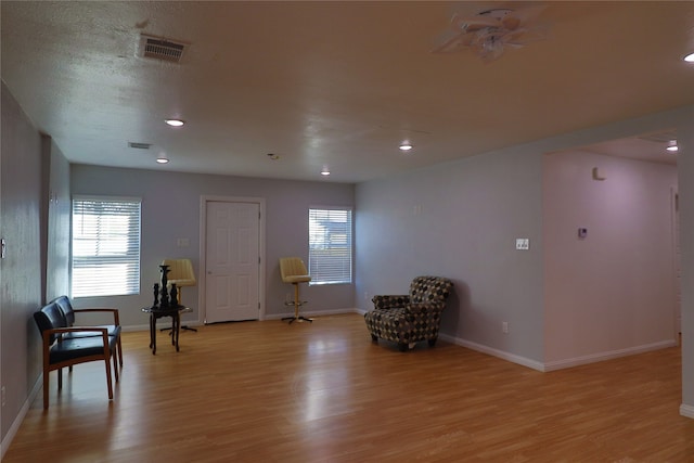 sitting room with a textured ceiling and light wood-type flooring