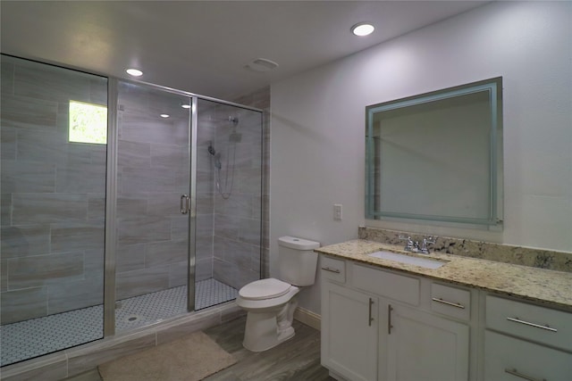 bathroom with vanity, toilet, hardwood / wood-style flooring, and an enclosed shower