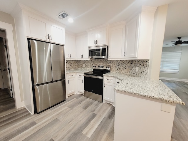 kitchen featuring light hardwood / wood-style flooring, stainless steel appliances, white cabinetry, kitchen peninsula, and ceiling fan