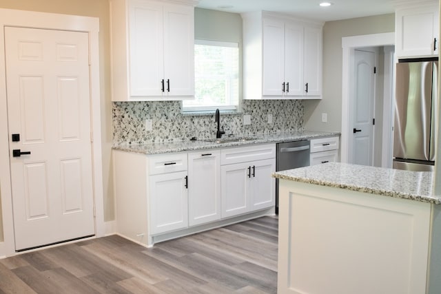 kitchen with light hardwood / wood-style flooring, stainless steel appliances, and white cabinetry