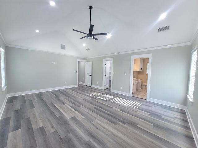 unfurnished bedroom with crown molding, lofted ceiling, light hardwood / wood-style flooring, and connected bathroom