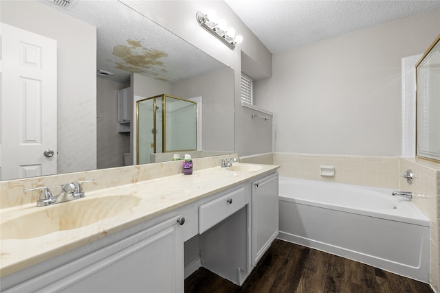 bathroom featuring a textured ceiling, vanity, hardwood / wood-style floors, and plus walk in shower