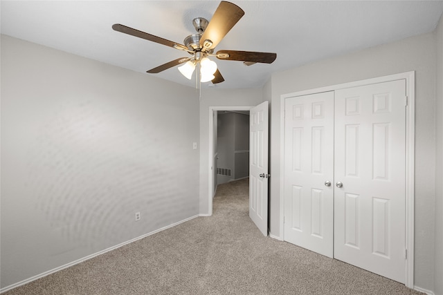 unfurnished bedroom with carpet flooring, ceiling fan, and a closet