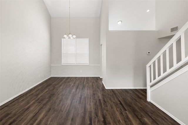 unfurnished room featuring high vaulted ceiling, dark hardwood / wood-style flooring, and a notable chandelier