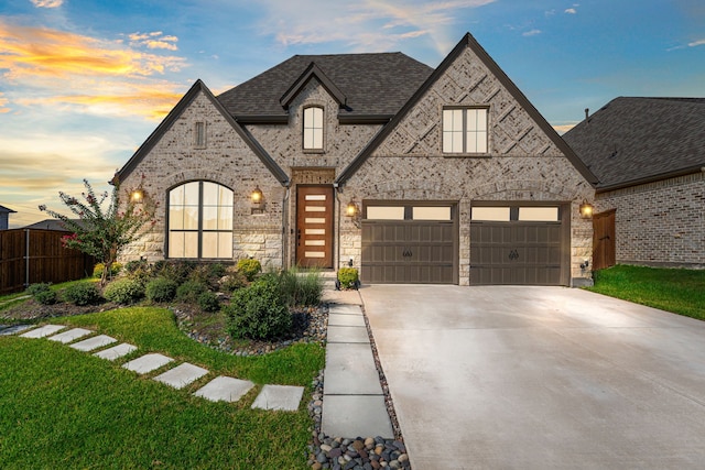 view of front of property featuring a garage and a yard