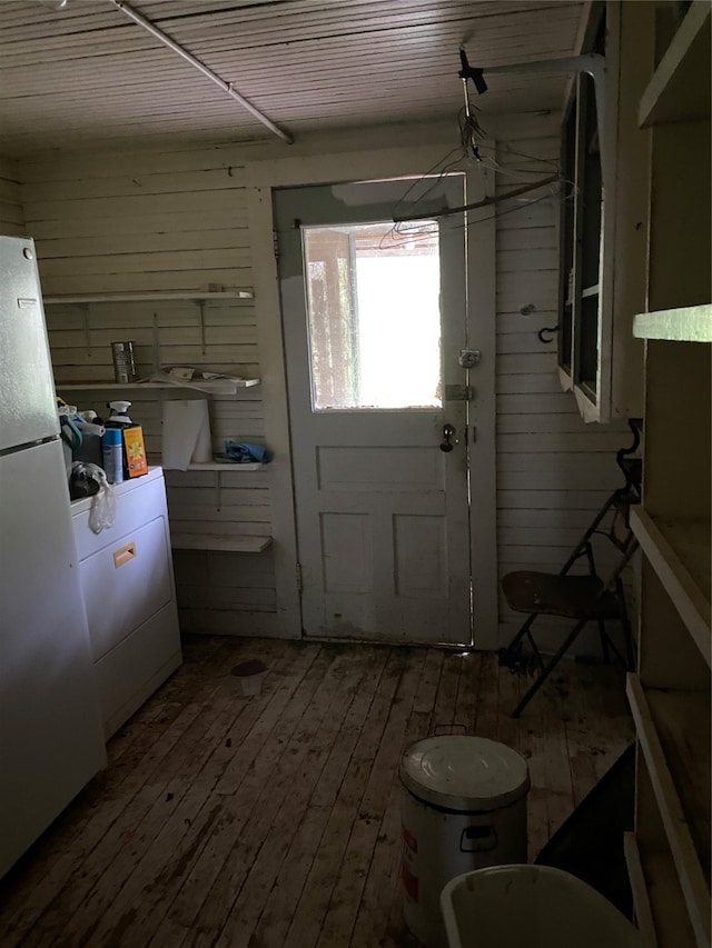 doorway to outside featuring wooden walls, hardwood / wood-style floors, and washer / dryer