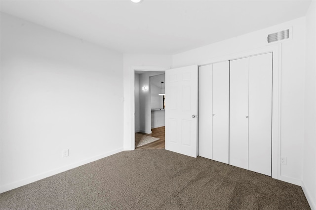 unfurnished bedroom featuring carpet and a closet