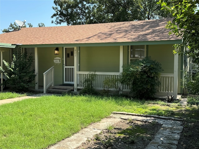 view of front facade with a front yard and covered porch