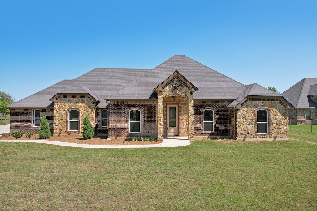 french country home featuring a front lawn