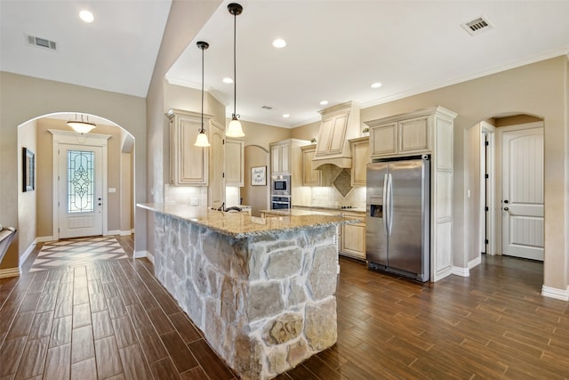 kitchen with stainless steel appliances, kitchen peninsula, light stone countertops, hanging light fixtures, and dark hardwood / wood-style floors