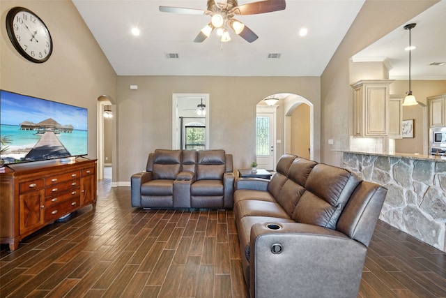 living room with ornamental molding, vaulted ceiling, dark hardwood / wood-style flooring, and ceiling fan