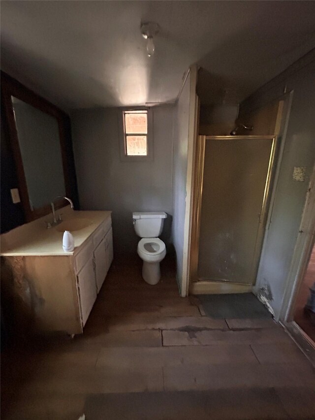 bathroom with vanity, toilet, hardwood / wood-style flooring, and walk in shower