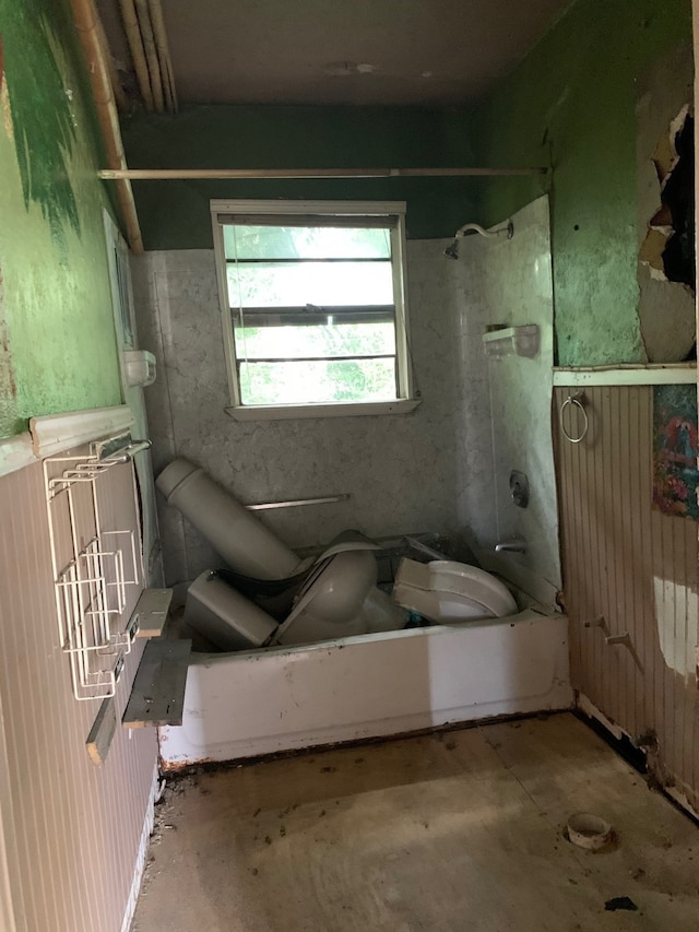 bathroom with toilet, concrete floors, and  shower combination