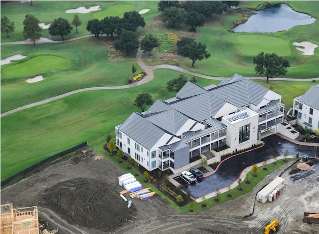 drone / aerial view with golf course view and a water view