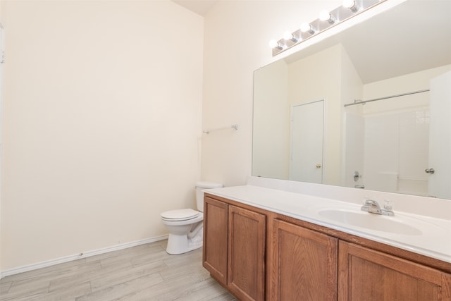 bathroom with a shower, hardwood / wood-style floors, toilet, and vanity