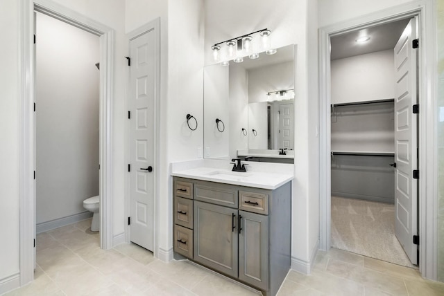 195 Coalson Xing, Azle, TX 76020 - bathroom with vanity, toilet, a walk in closet, baseboards, and tile patterned flooring