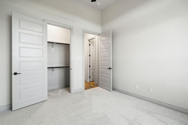 unfurnished bedroom featuring light carpet and a closet