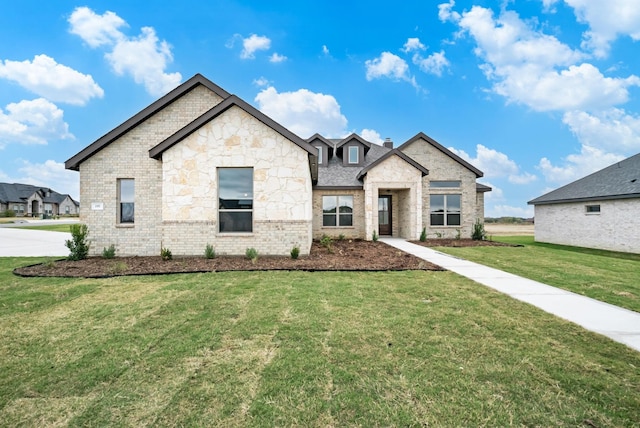 french country inspired facade featuring brick siding and a front lawn