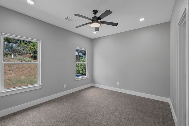 carpeted empty room with ceiling fan and plenty of natural light