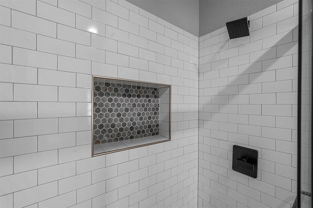 interior details featuring tiled shower