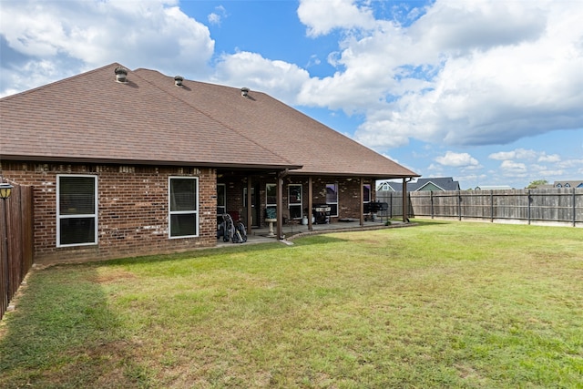 back of house featuring a lawn and a patio