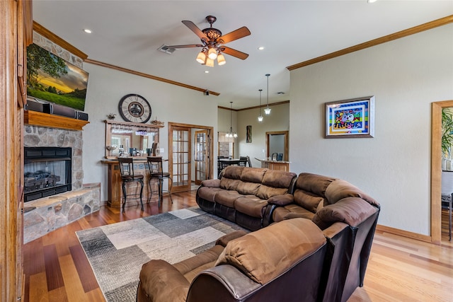 living room with ceiling fan, a fireplace, light hardwood / wood-style floors, and ornamental molding