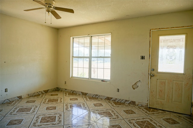 foyer entrance featuring a textured ceiling and ceiling fan