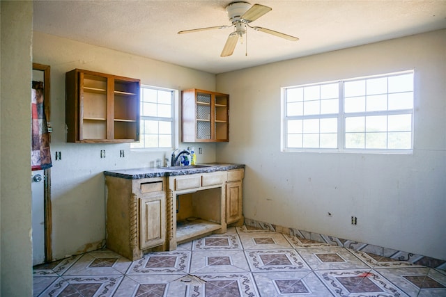 kitchen with ceiling fan, light tile patterned floors, a textured ceiling, and sink