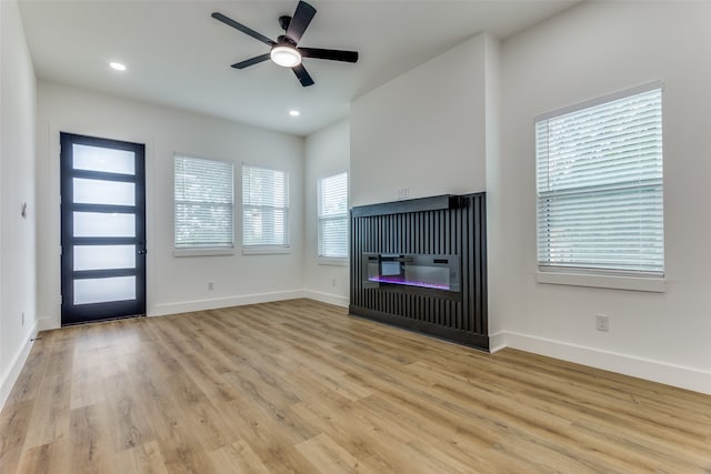 unfurnished living room with light hardwood / wood-style flooring and ceiling fan