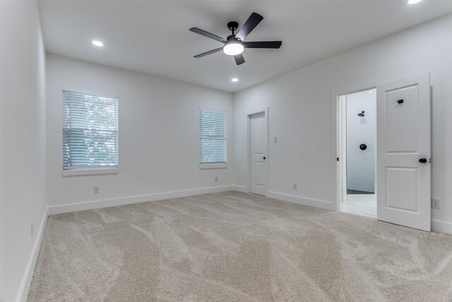 carpeted spare room with ceiling fan