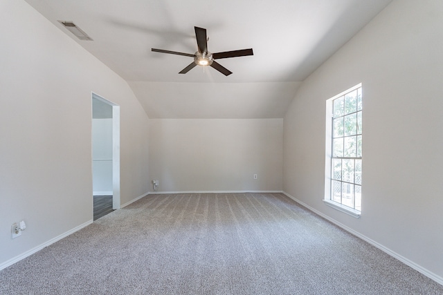 unfurnished room with vaulted ceiling, ceiling fan, and carpet