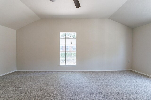 carpeted empty room with vaulted ceiling and ceiling fan