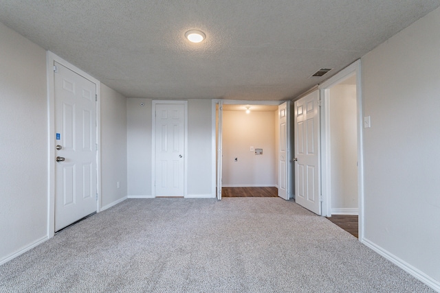 carpeted spare room with a textured ceiling and a healthy amount of sunlight