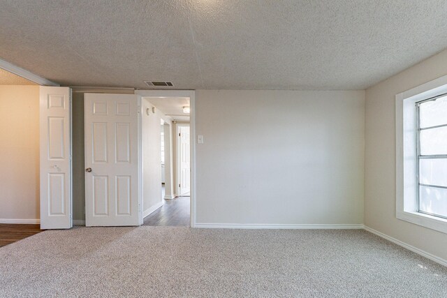 unfurnished bedroom with a textured ceiling and carpet flooring