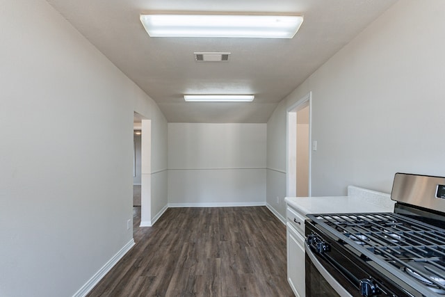 kitchen featuring stainless steel gas range oven, white cabinets, and dark hardwood / wood-style floors