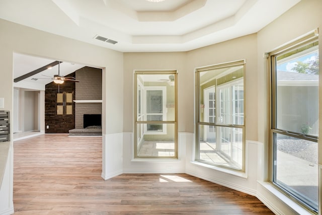 interior space with ceiling fan, a fireplace, and light hardwood / wood-style floors