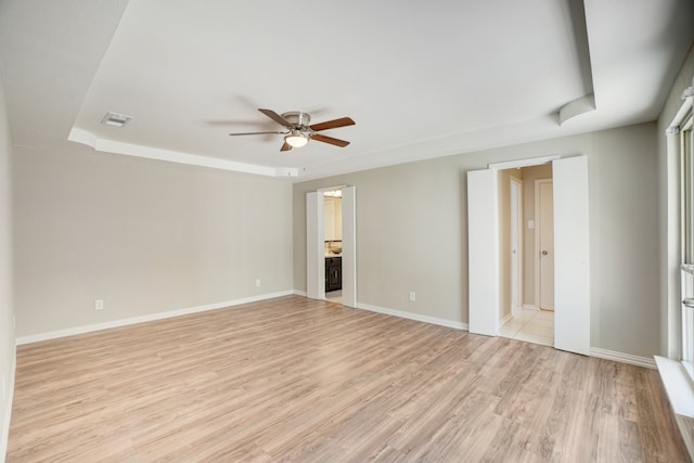 interior space with connected bathroom, light hardwood / wood-style floors, and ceiling fan