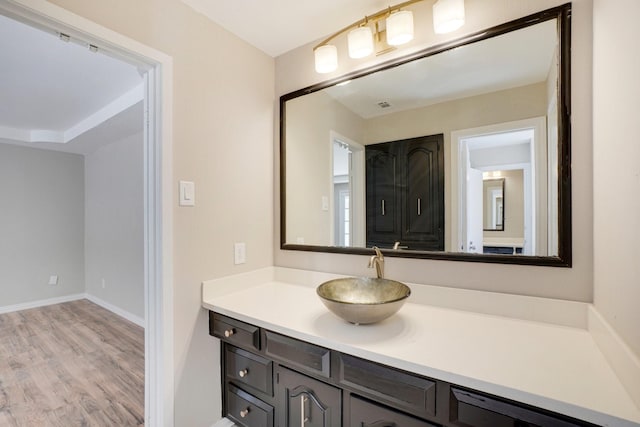 bathroom featuring vanity, wood finished floors, and baseboards
