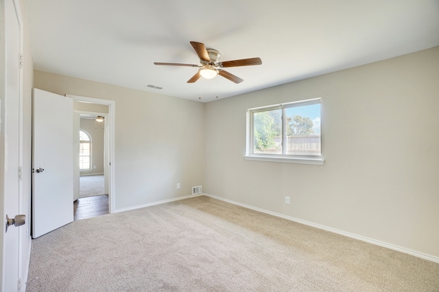 carpeted spare room with ceiling fan