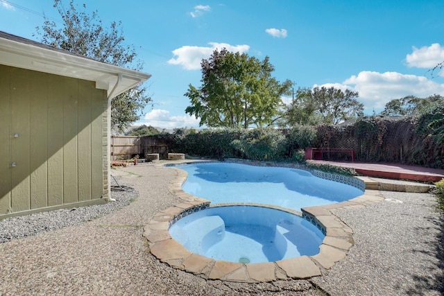 view of swimming pool featuring an in ground hot tub