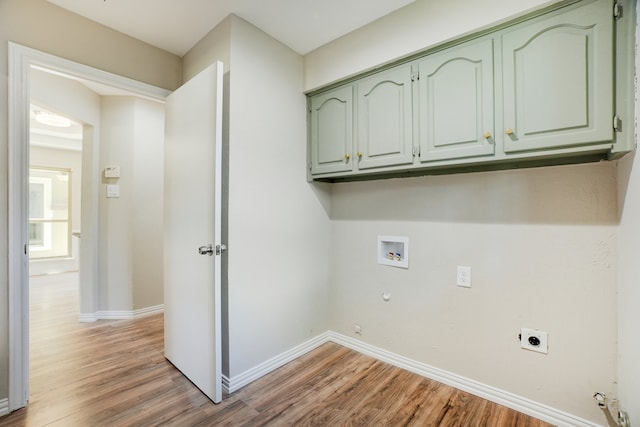 laundry room with gas dryer hookup, cabinets, hookup for a washing machine, hookup for an electric dryer, and wood-type flooring