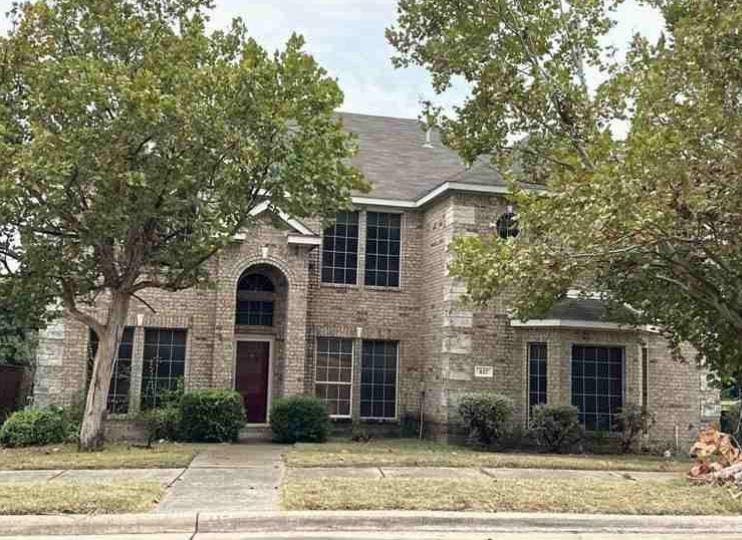 view of front of home with brick siding and a front yard