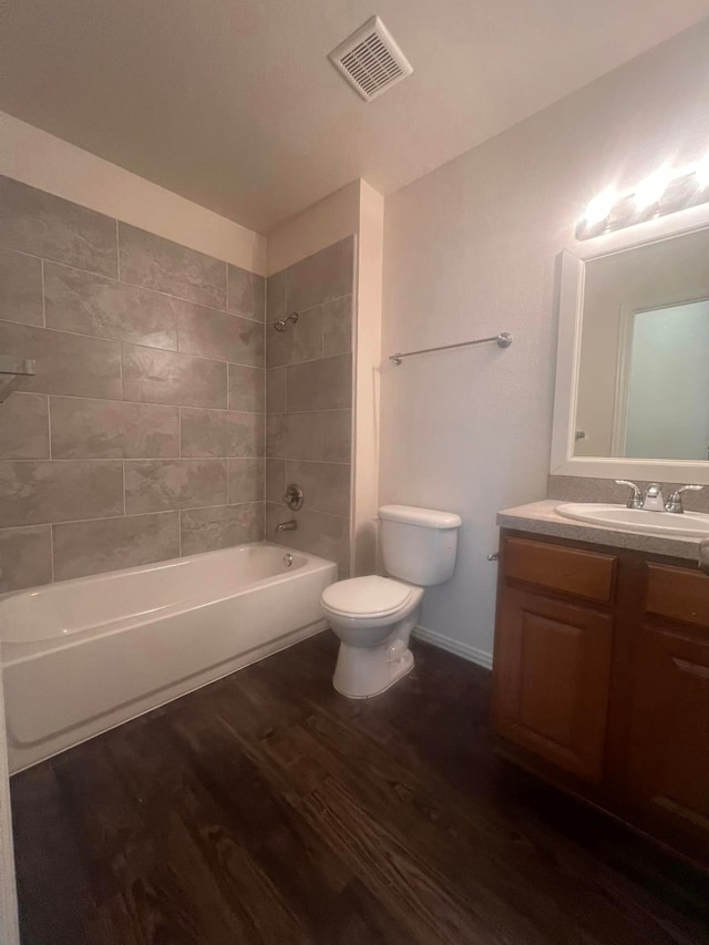 full bathroom featuring tiled shower / bath, vanity, toilet, and wood-type flooring