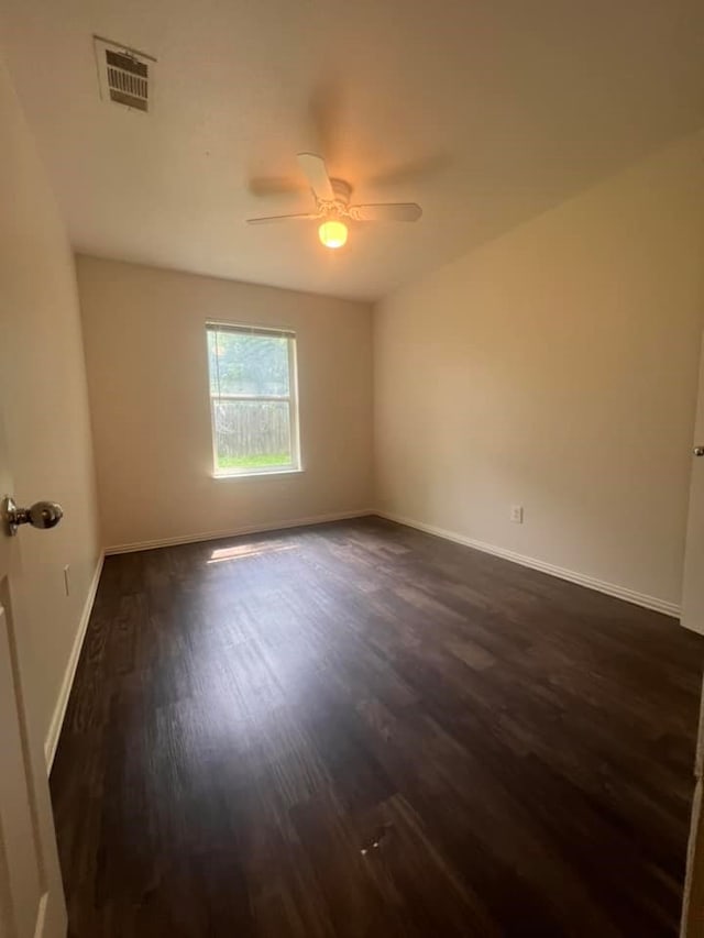 unfurnished room featuring dark wood-type flooring and ceiling fan