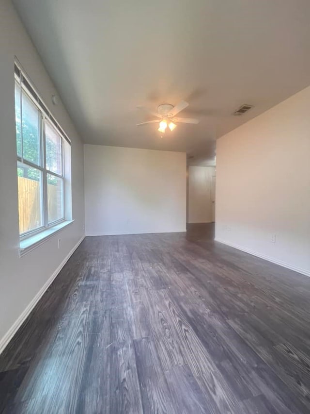 empty room featuring ceiling fan and dark hardwood / wood-style flooring