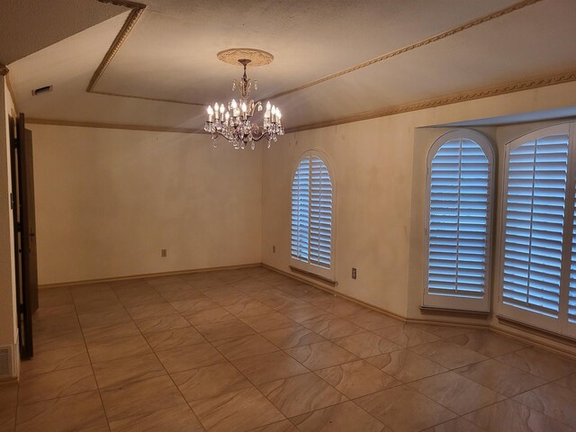 spare room featuring a notable chandelier, a textured ceiling, and ornamental molding