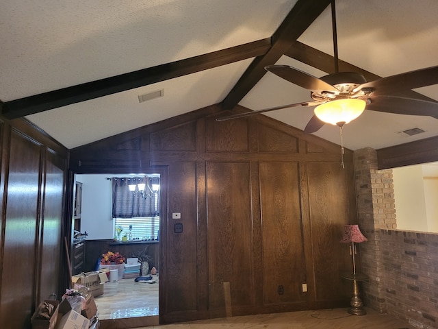 interior space with wooden walls, lofted ceiling with beams, and brick wall