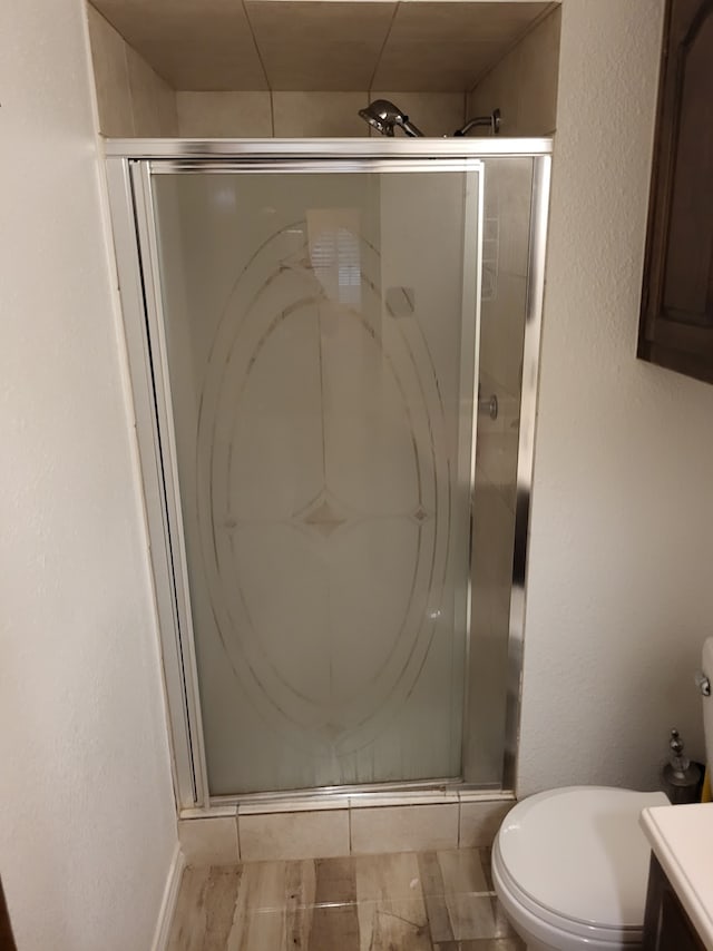 bathroom featuring vanity, toilet, and an enclosed shower